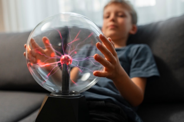 Foto gratuita niños interactuando con una bola de plasma.