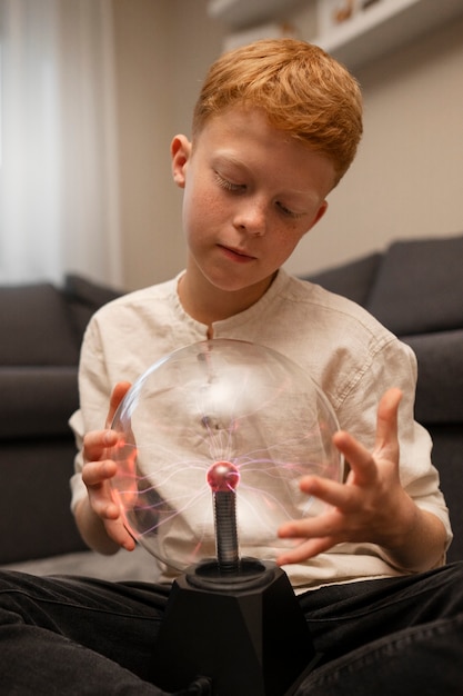 Foto gratuita niños interactuando con una bola de plasma.