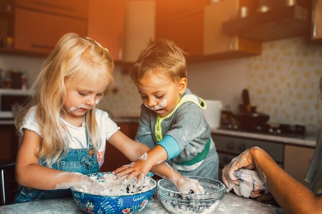 Los niños juegan con harina en la cocina.