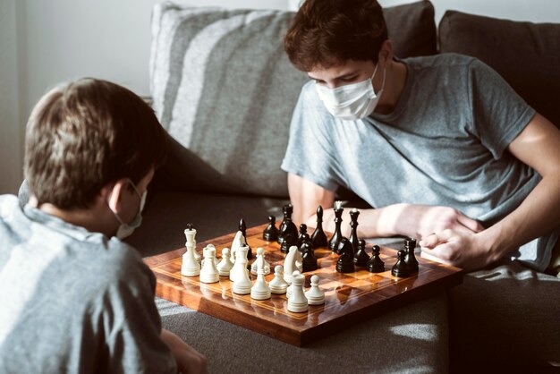 Niños jugando al ajedrez en casa mientras están en cuarentena