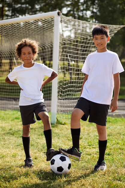 Foto gratuita niños jugando al fútbol supervisados por un entrenador de fútbol