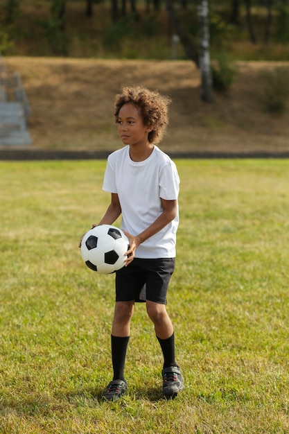 Foto gratuita niños jugando al fútbol supervisados por un entrenador de fútbol