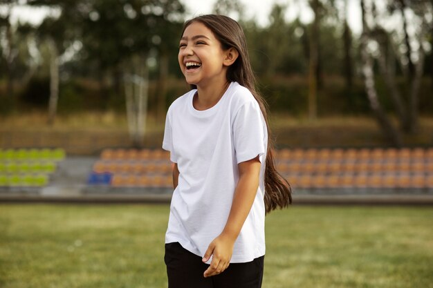 Niños jugando al fútbol supervisados por un entrenador de fútbol