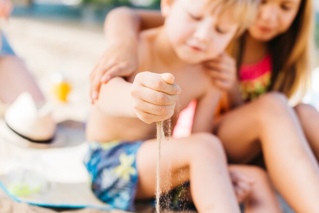 Niños jugando con arena en la playa