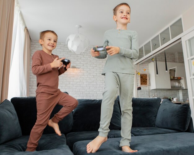 Niños jugando con un controlador en casa.