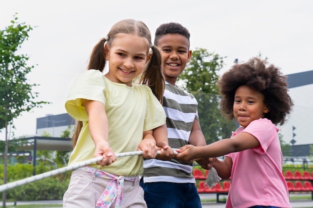 Niños jugando con cuerda de tiro medio.