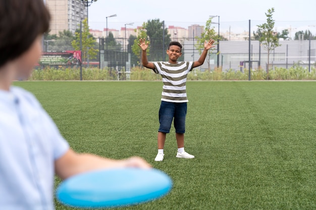 Niños jugando con frisbee de cerca