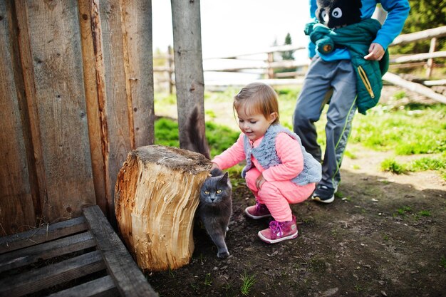 Niños jugando con gato en pueblo de montaña