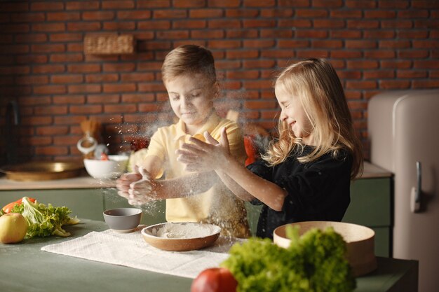 Niños jugando con una harina en una cocina