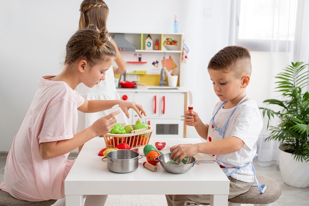 Niños jugando con un juego de cocina.