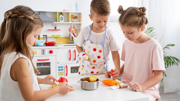 Niños jugando con un juego de cocina.