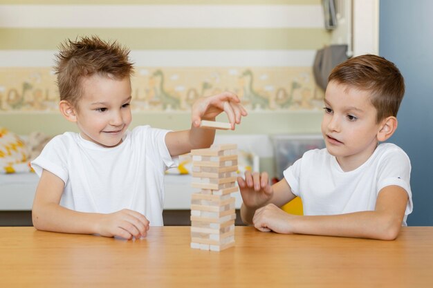 Niños jugando un juego de torre de madera.