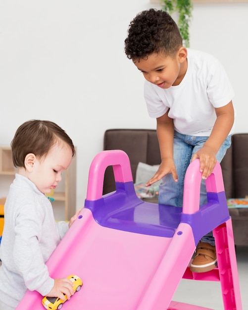 Niños jugando con juguetes y tobogán