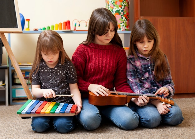 Niños jugando juntos con guitarra y xilófono