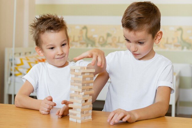 Niños jugando juntos a un juego de torre de madera.