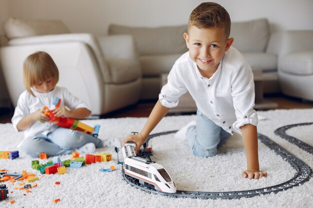 Niños jugando con lego y tren de juguete en una sala de juegos