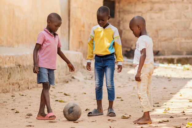 Niños jugando con pelota de tiro completo