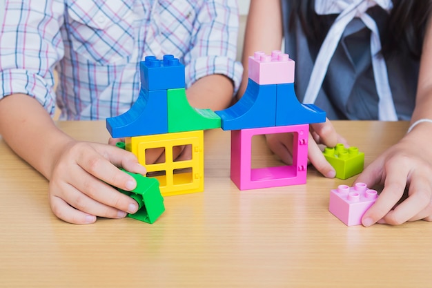 Foto gratuita niños jugando piezas de plástico de construcción creativa.