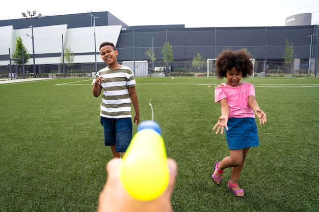 Niños jugando con pistola de agua de cerca