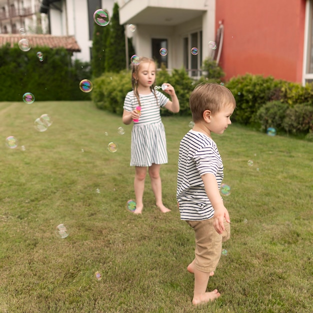 Niños jugando con soplador de burbujas