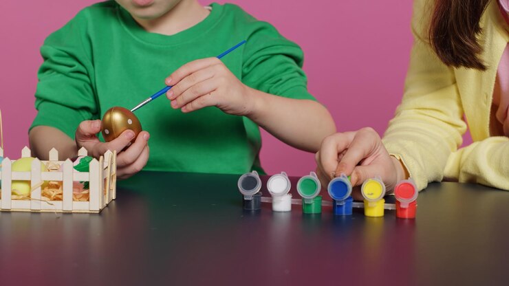 Foto gratuito niños juguetones pintando huevos con acuarela y pinceles