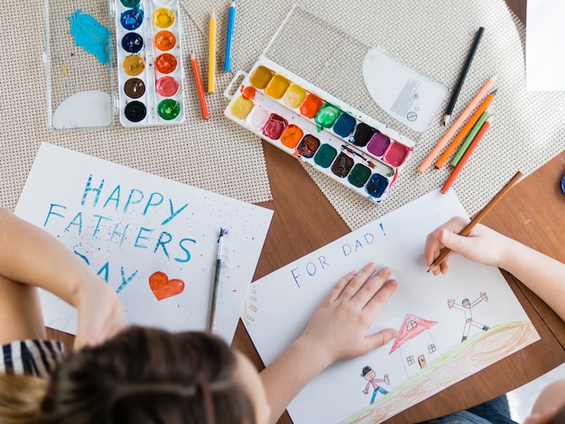 Niños laicos planos dibujando para el día del padre