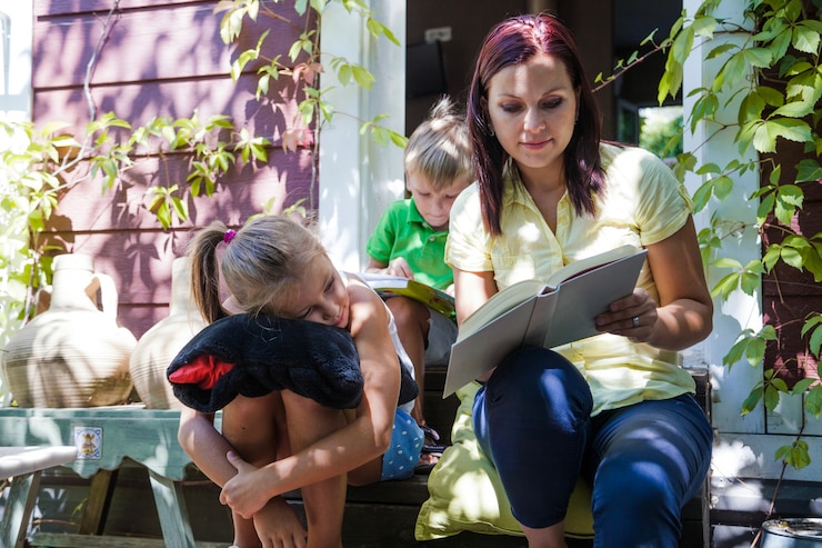 Foto gratuito niños con la lectura de la madre en el pórtico