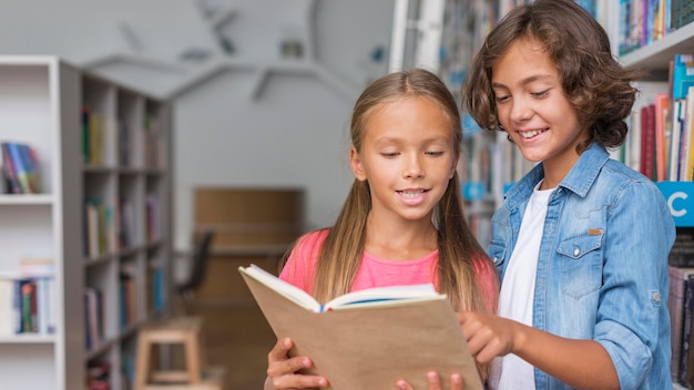 Foto gratuita niños leyendo un libro con espacio de copia.