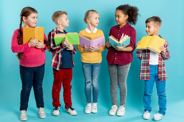 Foto gratuita niños con libros mirándose