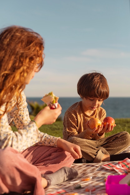 Niños lindos comiendo al aire libre