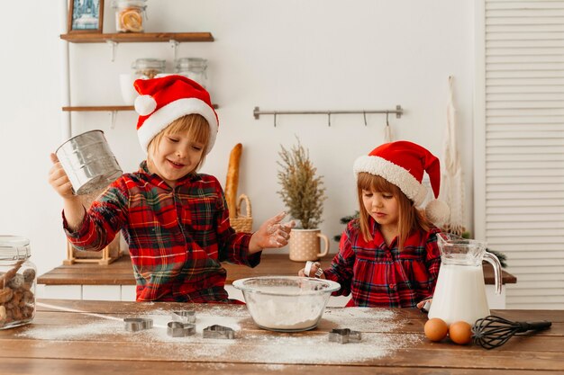 Niños lindos haciendo galletas juntos el día de Navidad