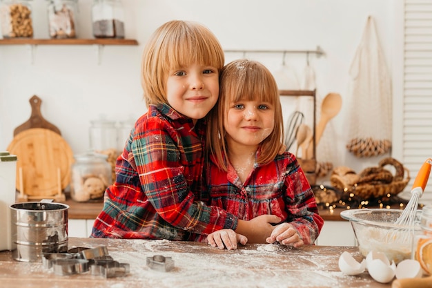 Niños lindos haciendo galletas de Navidad juntos