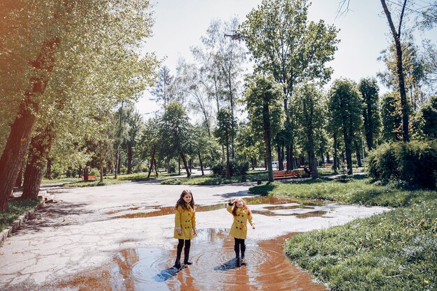 Niños lindos plaiyng en un día lluvioso