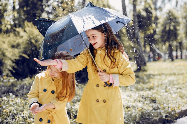 Niños lindos plaiyng en un día lluvioso