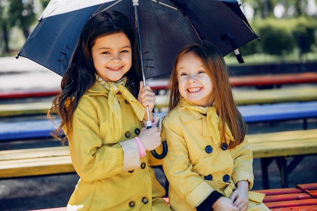 Niños lindos plaiyng en un día lluvioso