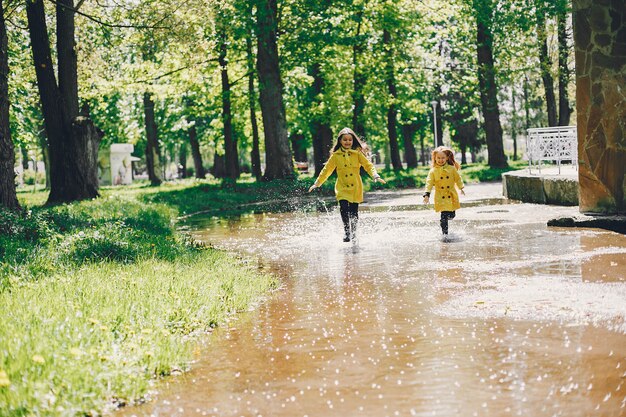 Niños lindos plaiyng en un día lluvioso