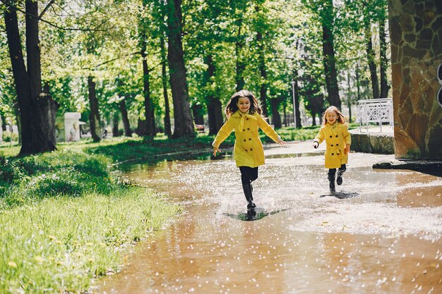 Niños lindos plaiyng en un día lluvioso