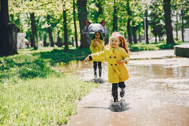 Niños lindos plaiyng en un día lluvioso