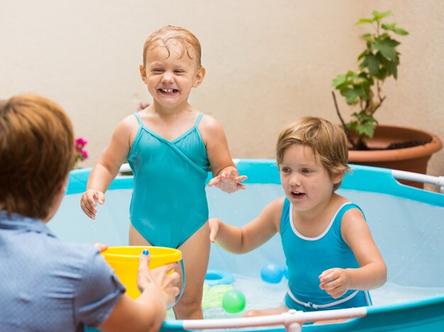 Niños y madre jugando en la piscina