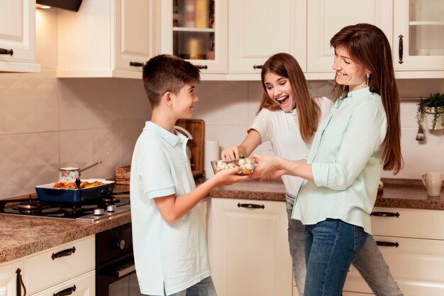 Niños y madre preparando comida en la cocina