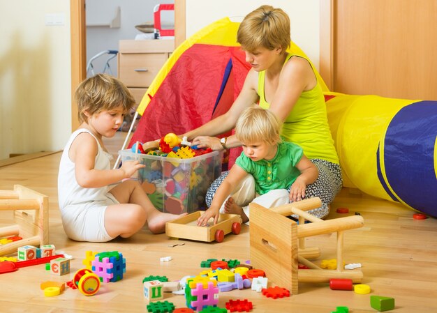 Niños y madre recogiendo juguetes