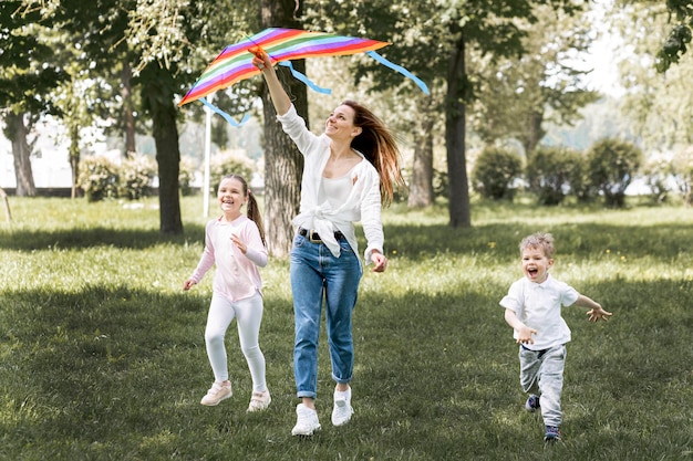 Niños y mamá jugando con coloridos cometas