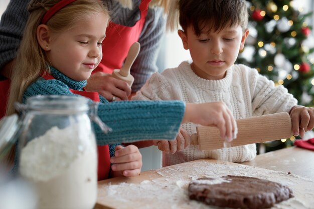 Niños y mamá preparando masa para galletas de jengibre