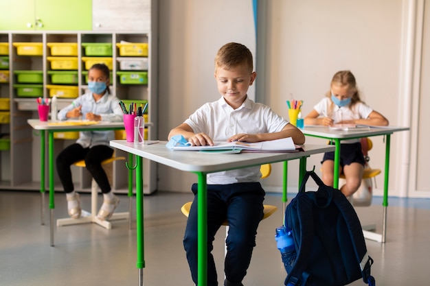 Niños manteniendo la distancia social en el aula.