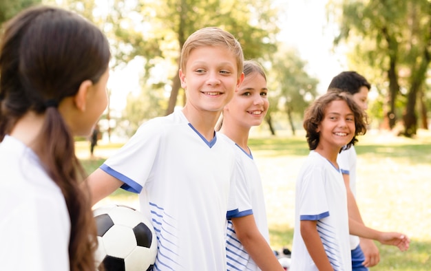 Niños mirándose antes de un partido de fútbol.