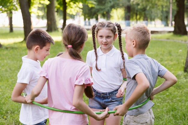 Niños y niñas jugando con hula hoop.