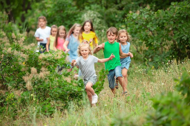 Niños, niños corriendo en prado verde