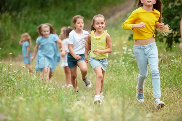 Niños, niños corriendo en prado verde