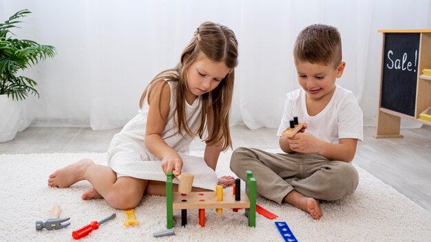 Niños no binarios jugando con juego colorido.