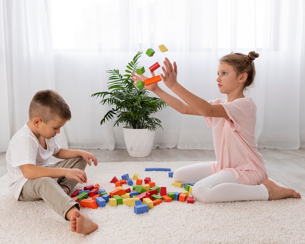 Niños no binarios jugando juntos con un juego educativo.